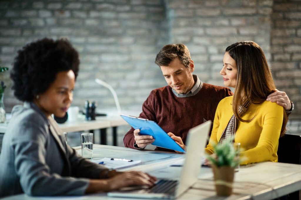 African American woman at desk with white couple